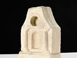 a small stone building with a window on top of it