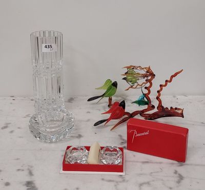 un vase en verre, un bougeoir et une boîte posés sur une table