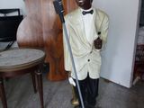 une statue représentant un homme en smoking, muni d'une canne