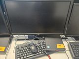 trois écrans d'ordinateur et un clavier posés sur un bureau