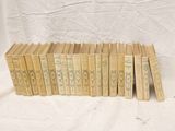 several books are stacked on top of each other on a white surface