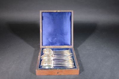 silverware in a wooden case on a black surface