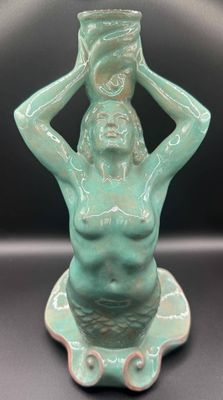a statue of a woman holding a pot on her head