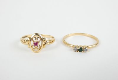 two gold rings, one with a heart and the other with a ruby stone