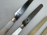 five knives and a knife holder on a table