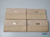 quatre portefeuilles en cuir beige posés sur une table bleue