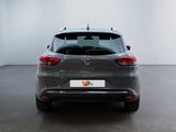 the rear end of a grey car in a white room