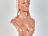 sculpture of a female bust on a wooden base on a white surface