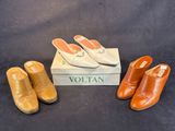 trois paires de chaussures et une boîte posées sur une surface noire