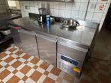 a stainless steel kitchen with a sink and a stove