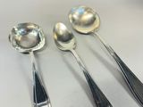 three spoons and two spoons sitting on a table