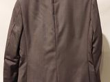 the back of a jacket hanging on a hanger on a wall
