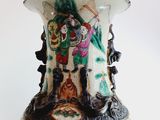 a vase with a painting on it sitting on a table