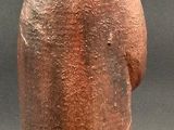 a small statue of a man with a rock on his head