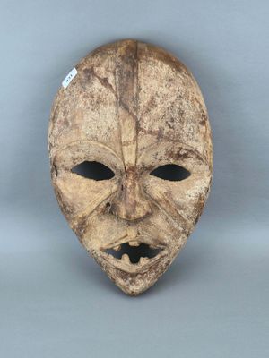 gros plan d'un masque en bois sur une surface blanche
