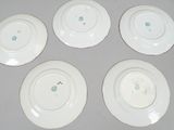 six white plates with different designs on them sitting on a table