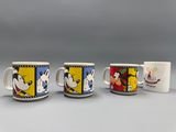 Trois tasses à café Disney sont alignées sur une table