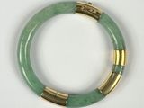 un gros plan d'un bracelet vert posé sur une surface blanche