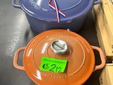 Plusieurs casseroles et poêles sont posées sur une table dans un magasin.