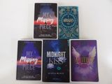 four books are sitting on a white table with a white background