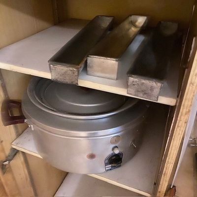 une casserole et une poêle posées sur une étagère dans un placard