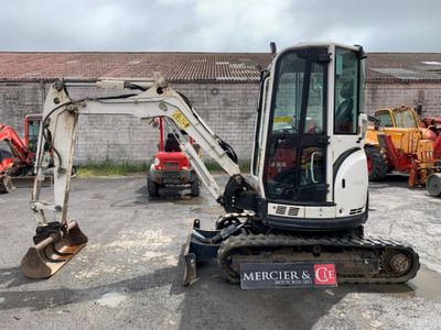 a small excavator that is parked in a parking lot