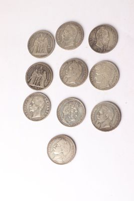 several coins are arranged in the shape of a heart on a white surface