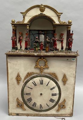 une petite horloge surmontée de figurines