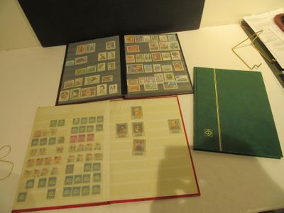 beaucoup de timbres posés sur une table, à côté d'un livre