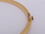 a close up of a gold plated bracelet on a white surface