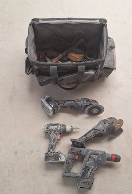 des outils posés par terre à côté d'un sac