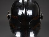an old helmet on a stand on a black background