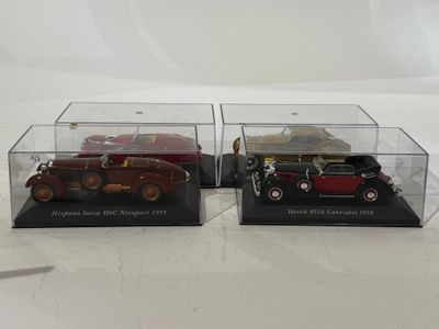 two model cars in a display case on a white surface
