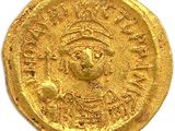 a close up of a gold coin on a white surface