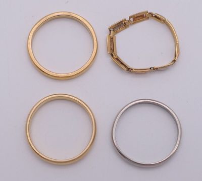three gold and silver rings on a white surface