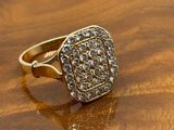 a close up of a gold ring with diamonds on a wooden surface