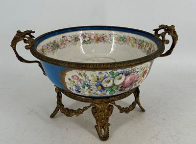 un bol bleu et blanc posé sur un socle et orné de fleurs