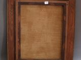 an old wooden frame with a brown mat on it