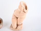 two clay figurines sitting next to each other on a white surface