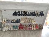 many pairs of shoes that are lined up on a shelf