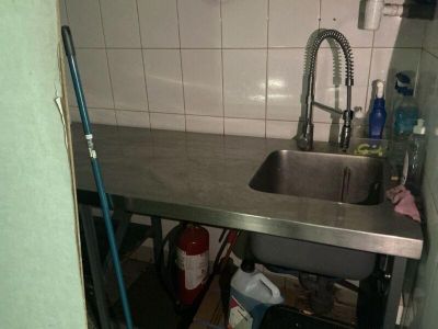 a sink in the corner of a small kitchen