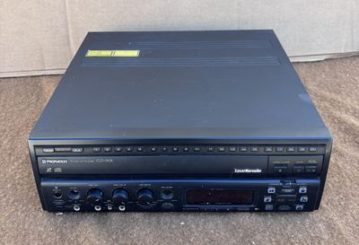 un lecteur CD noir posé sur un sol recouvert de moquette