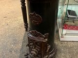 un vase noir posé sur le trottoir devant une vitrine