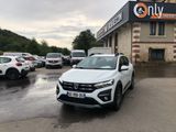 La voiture blanche est garée devant un immeuble devant lequel sont garées d'autres voitures.