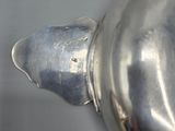 a close up of a silver tea pot on a table