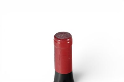 a red wine bottle with a black cap on a white background