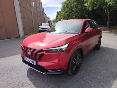a red car parked in a parking lot next to a building
