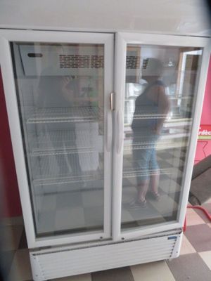 a white refrigerator with two glass doors in a room