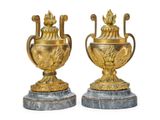une paire de vases en or et en argent posés sur des socles en marbre, sur fond blanc