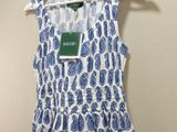 a white and blue dress hanging on a hanger next to a wall